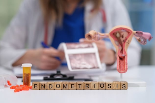 Medical Professional sitting behind wooden cubes spelling out endometriosis